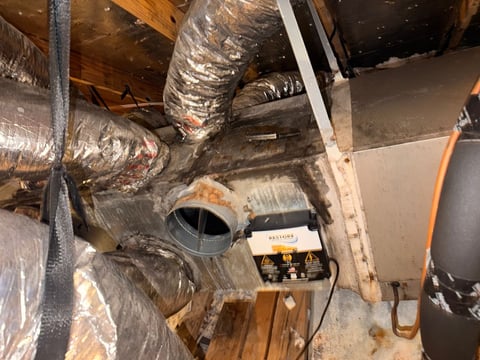 HVAC ductwork with insulation and a control unit in attic