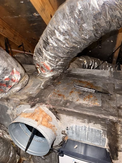 Dirty HVAC ductwork and flexible aluminum tubing in an attic